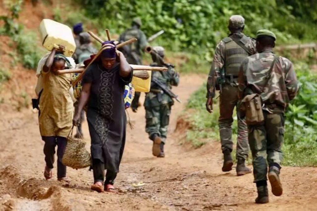 Personas desplazadas cargando con las pocas pertenencias que les quedan en el este del Congo – Kenny Katombe / The New Humanitarian