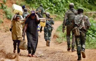 Personas desplazadas cargando con las pocas pertenencias que les quedan en el este del Congo – Kenny Katombe / The New Humanitarian